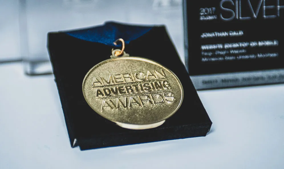 a gold medal on a black box, web design award, mushy media